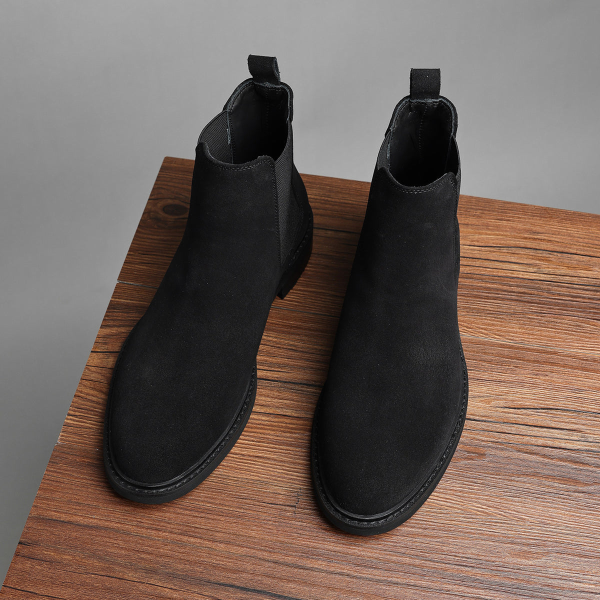 Pair of black Chelsea dress boots with side elastic gore and low stacked heel.