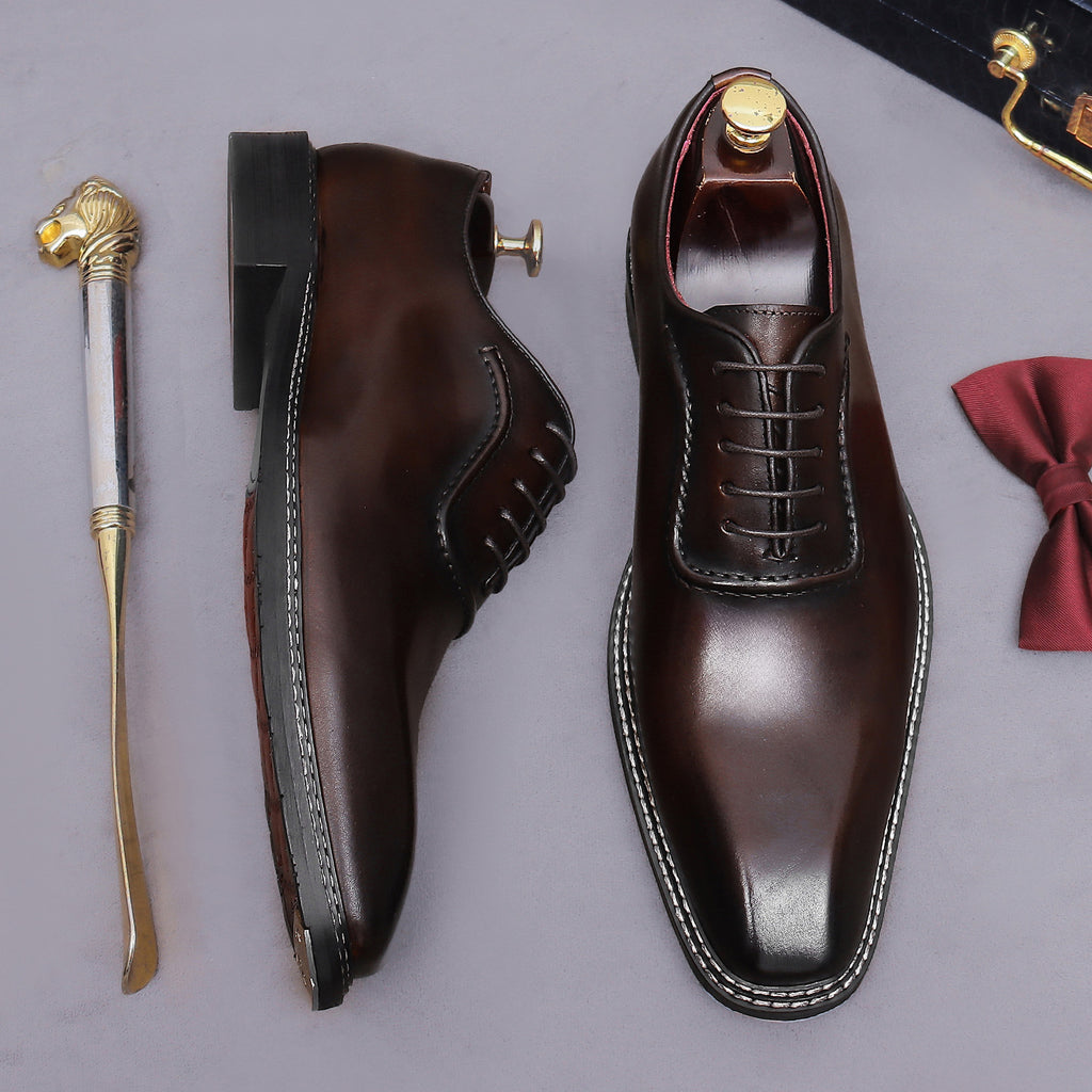 Men's chunky lug sole wingtip brogue oxford shoes in dark brown, side and front angle view.