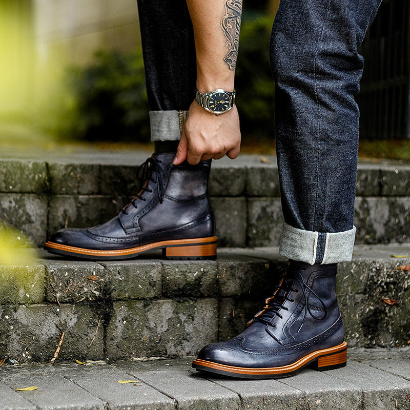 Men's dark leather lace-up chukka boots with tread sole, worn with dark jeans
