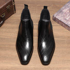 Pair of black leather Chelsea dress boots with elastic gore and low-profile heel