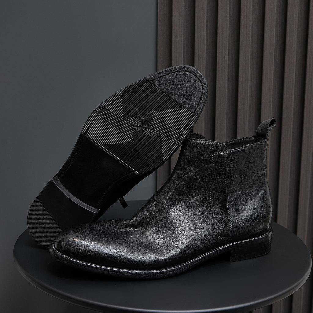 Black leather ankle boots with side zipper, pointed-toe, and textured sole