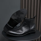 Black leather ankle boots with side zipper, pointed-toe, and textured sole