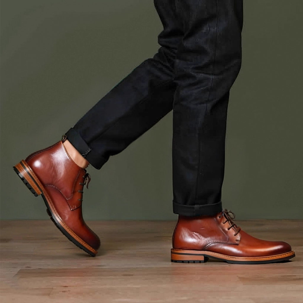 Men's brown leather chukka boots with lace-up closure and plain toe, on light wood floor