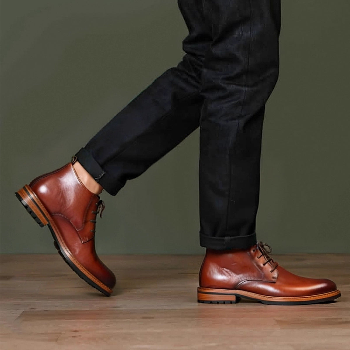 Men's brown leather chukka boots with lace-up closure and plain toe, on light wood floor