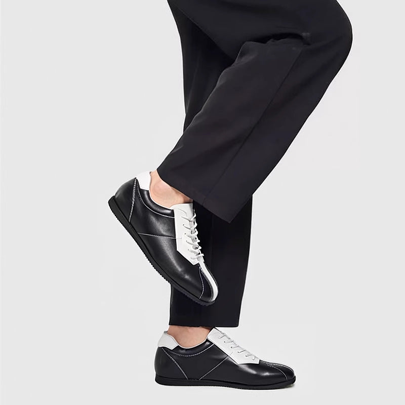 Black leather sneakers with white laces and contrast side panels, low profile.