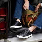 Pair of men's black leather lace-up sneakers with white rubber soles