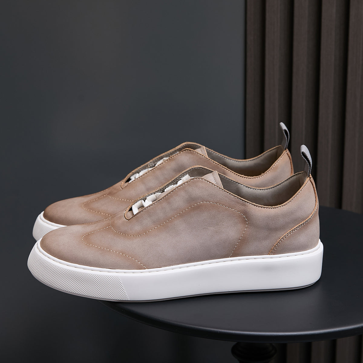 Beige leather sneakers with strap detail, lace-up, and white rubber sole