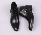 Men's black leather dress boots showing side zipper and buckle strap, thick sole.