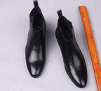 Black leather Chelsea boots with back pull tabs, rounded toe, and lining