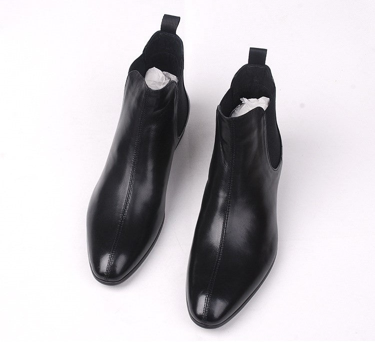 Pair of black leather Chelsea dress boots with elastic gore and rounded toe.