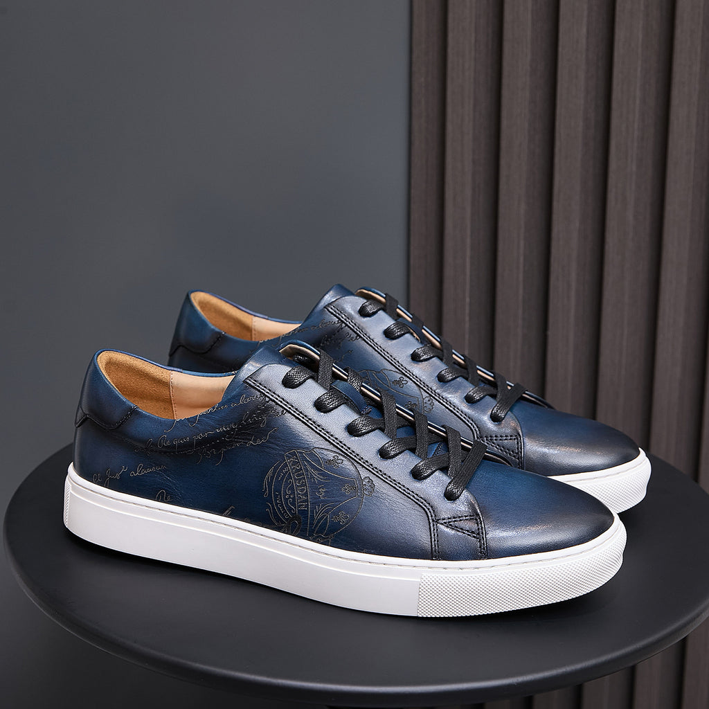 Leather sneakers, dark blue with black laces, embossed side detail, and white sole