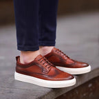 Men's genuine leather sneakers, brown lace-up with perforated toe and white rubber sole.