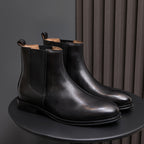Black pointed-toe Chelsea boots on display with elastic side panels