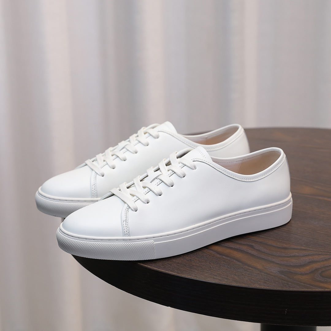 Men's leather sneakers, white low-top with lace-up front and rubber sole.