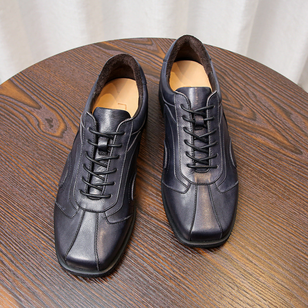 Men's leather sneakers pair in dark gray, lace-up front with stitched panels