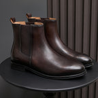 Dark brown pointed-toe Chelsea boots on display with elastic side panels