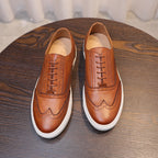 Pair of men's brown leather sneakers with lace-up front and white sidewall sole