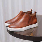 Brown leather side-zip dress boot with pointed toe and white rubber sole