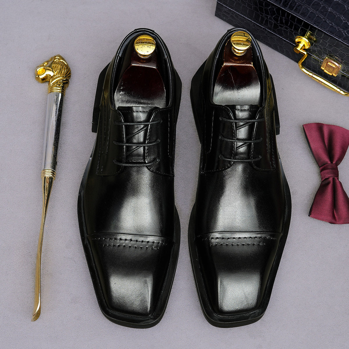 Men's black leather lace-up derby dress shoes, pointed toe with stitched vamp and laces.
