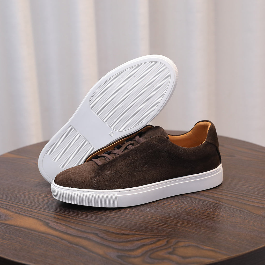 Brown suede leather sneakers showing treaded white outsole and lace-up front