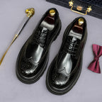 Men's leather pointed-toe derby shoes, lace-up with brogue holes and dark patina polish.