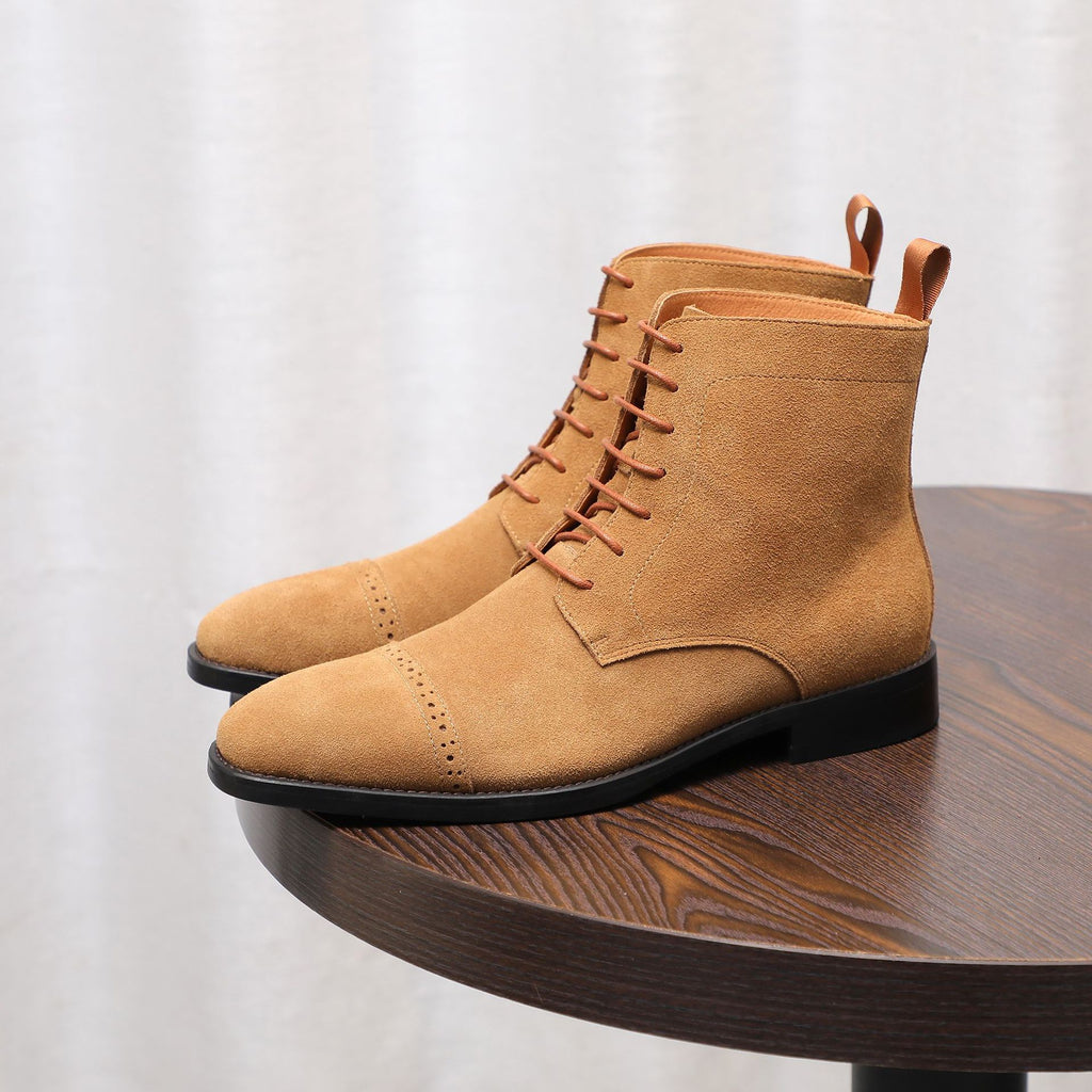 Tan suede lace-up chukka boot with stitched toe and black rubber sole