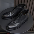 Black leather lace-up chukka boots, angled side view showing smooth plain toe.