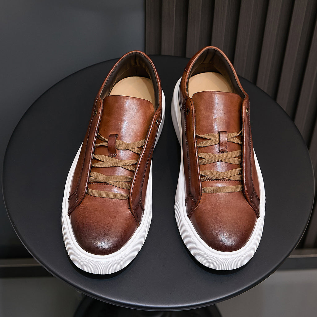 Pair of men's brown leather sneakers with lace-up ties and white rubber platform