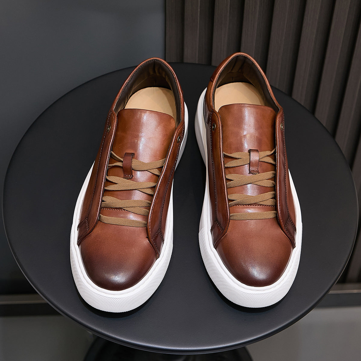 Pair of men's brown leather sneakers with lace-up ties and white rubber platform