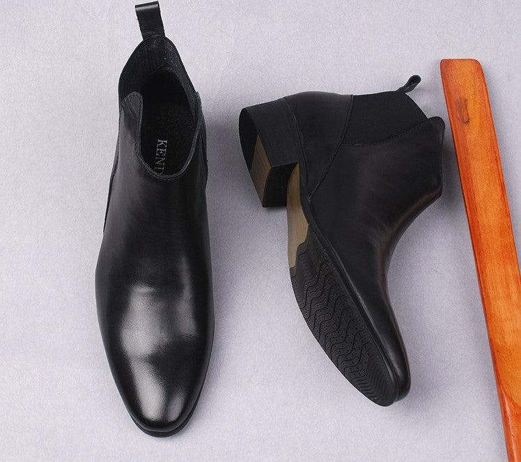 Black leather Chelsea boots with textured sole, side elastic panels, and block heel