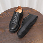 Men's black leather sneakers with textured tread sole, lace-up casual shoes