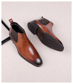 Brown leather Chelsea boots, side profile showing elastic gore and textured outsole