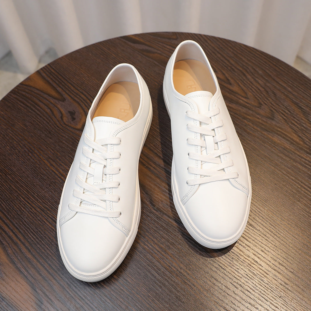 Men's leather sneakers, white low-top lace-up style with tan lining.