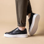 Men's black leather sneakers with lace-up front and textured white outsole
