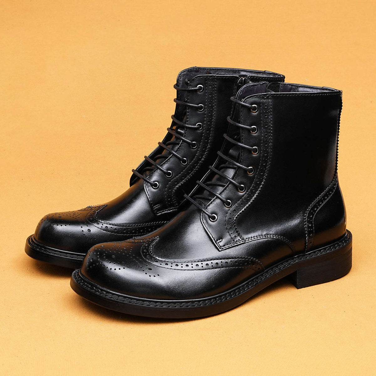 Black leather lace-up boots with wingtip perforations and thick platform sole