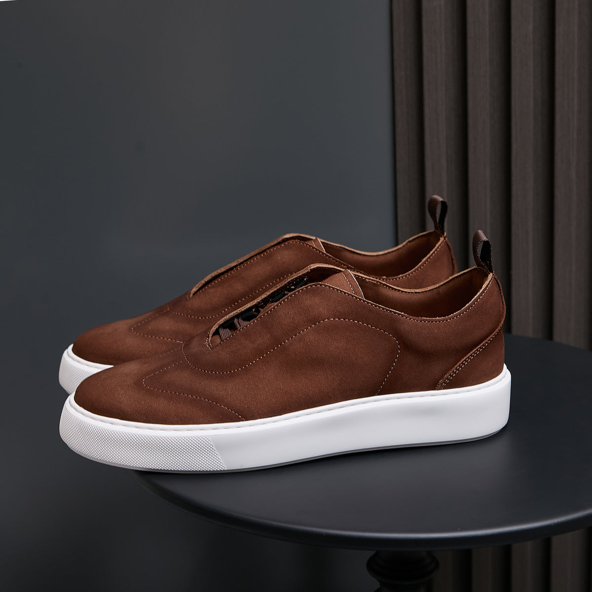 Dark brown leather sneakers with lace-up front and white rubber sole