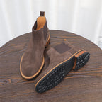 Men's suede chelsea dress boots in dark brown with treaded outsole view and side elastic