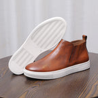 Brown leather side-zip dress boot showing treaded outsole with white rubber sole