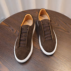 Pair of brown suede leather low-top sneakers with lace-up ties and white soles