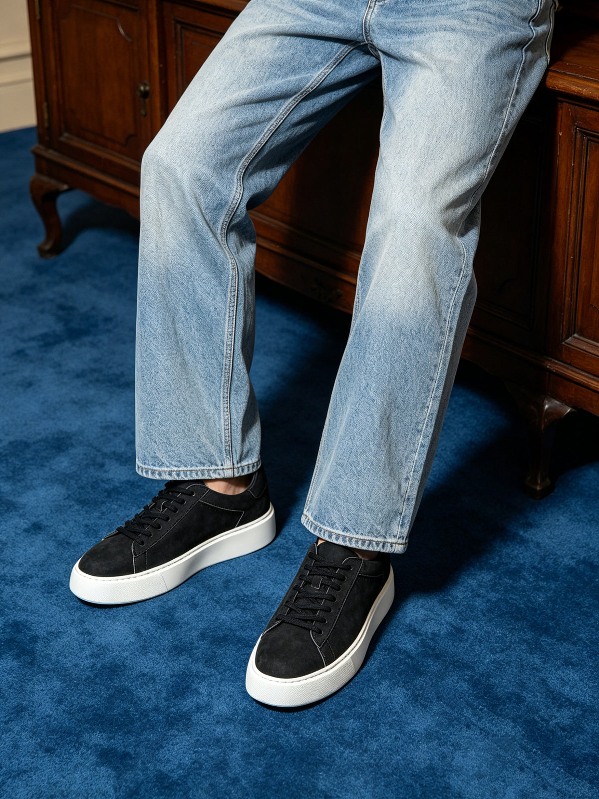 Black leather low-top sneakers with black laces and white platform sole