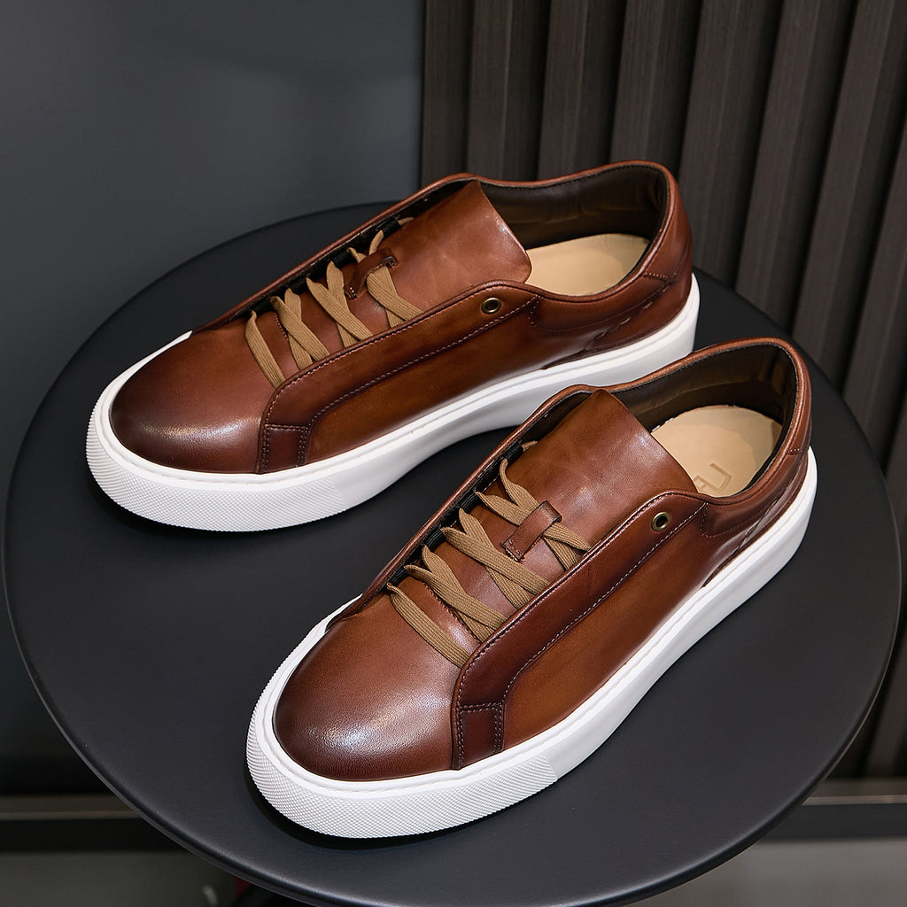 Men's brown leather sneakers with tan laces, side profile, and white platform sole