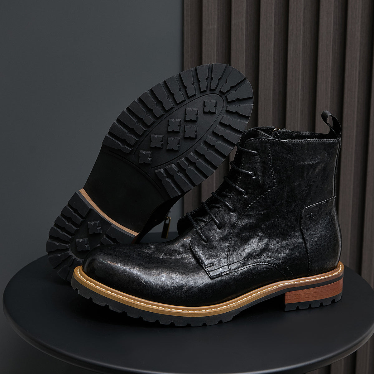 Men's black leather boots with pointed toe, lace-up design, and side zipper.