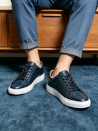 Men's leather sneakers, dark blue with white soles and black lace-up, worn with jeans