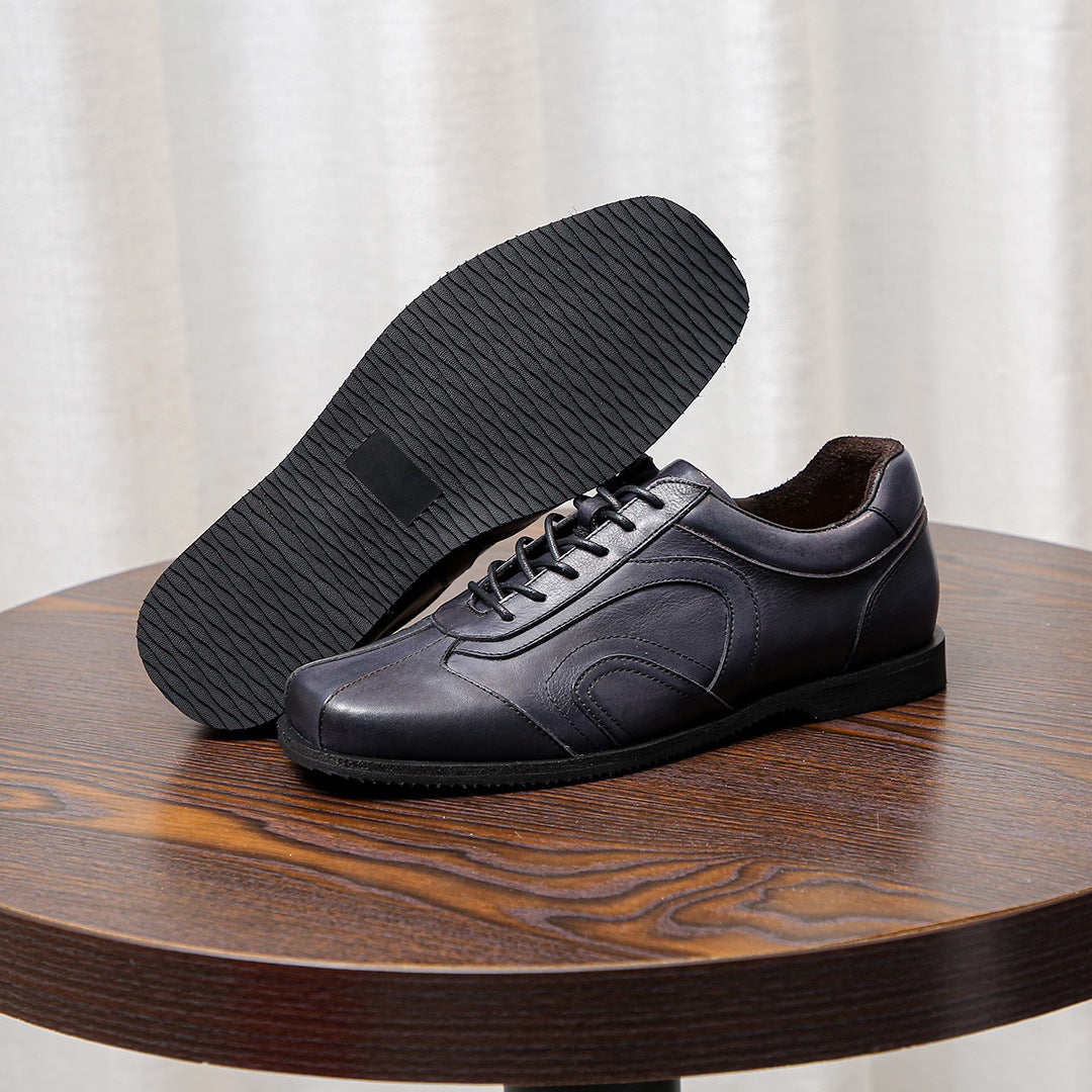 Men's dark gray leather sneakers with textured tread outsole and lace-up front