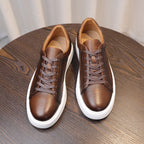 Dark brown leather sneakers shown top view with lace-up closure and white soles.