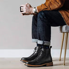 Black leather lace-up side-zip dress boots with cap toe, worn with jeans