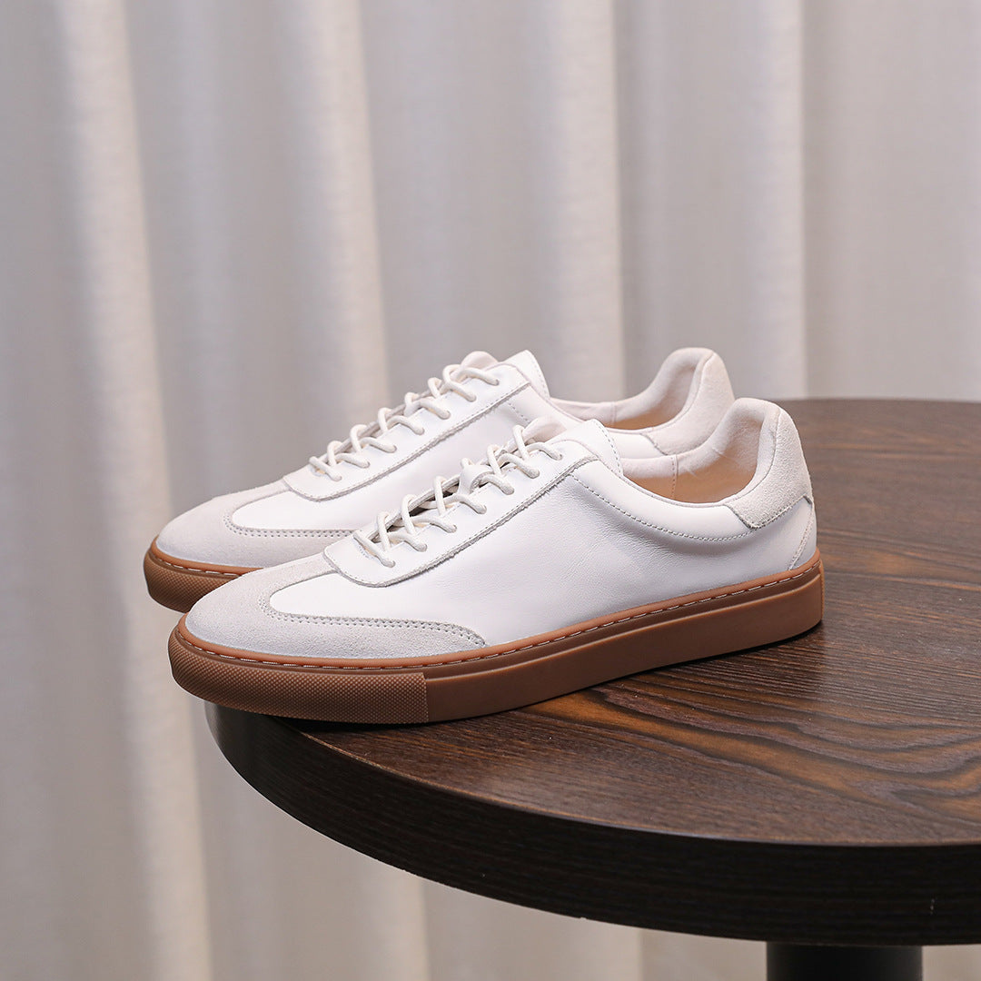 Pair of white leather lace-up sneakers with tan rubber sidewall