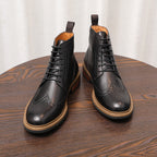 Black leather lace-up chukka boots with perforated toe and light tan sole edge