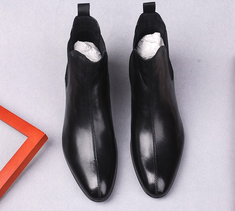 Black leather slip-on Chelsea boots with elastic side panels and pull tabs inside.