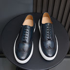 Dark blue leather lace-up sneakers, front view with white rubber soles